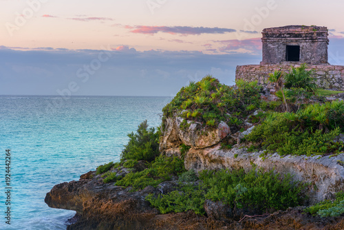 Mayan temple at sunset on tulum cliffs overlooking caribbean sea