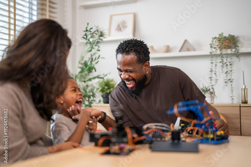 Photography Diverse family building robot toy together at home, african american father, cau