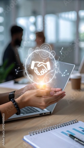 A digital handshake graphic floats above an open laptop representing modern business and connection high quality