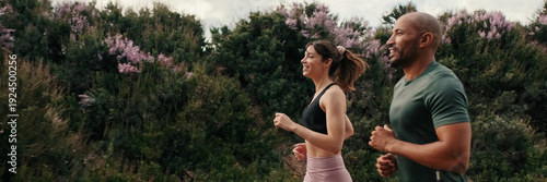 Fotografie Side view of jogging multiethnic woman and man enjoy their outdoors workout in summer