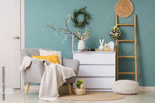 Interior of living room with Easter wreaths, armchair and ladder