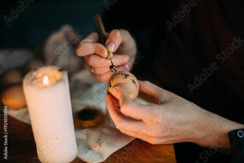 Hands decorating traditional ukrainian pysanka easter egg