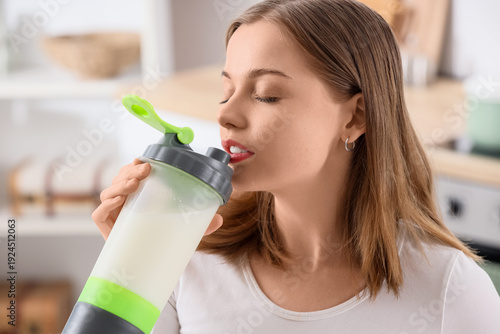 Sporty young woman drinking...