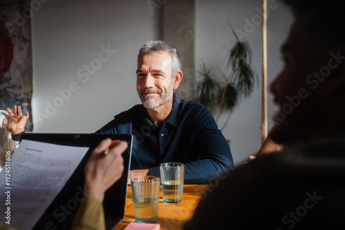 Smiling man participates in a meeting