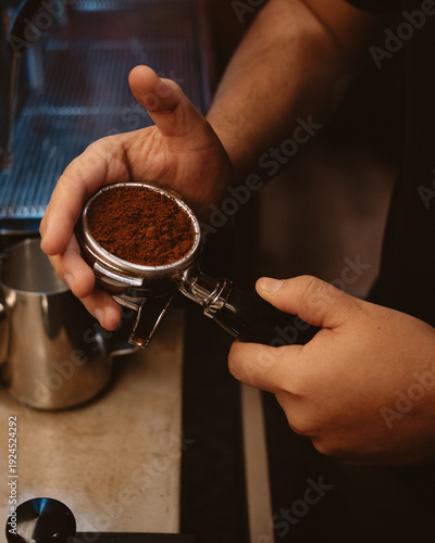 Tableau sur toile Close-up of a barista holding a portafilter filled with freshly ground coffee, ready for tamping and espresso extraction