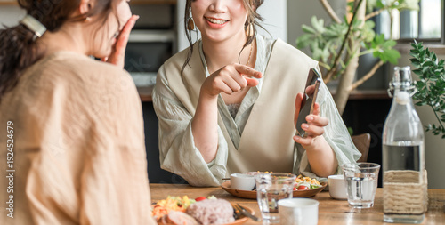 Tableau sur toile Cafe, coffee shop, woman talking while looking at smartphone at dining table