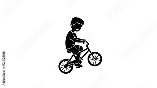 Silhouette of a young boy riding a bicycle.