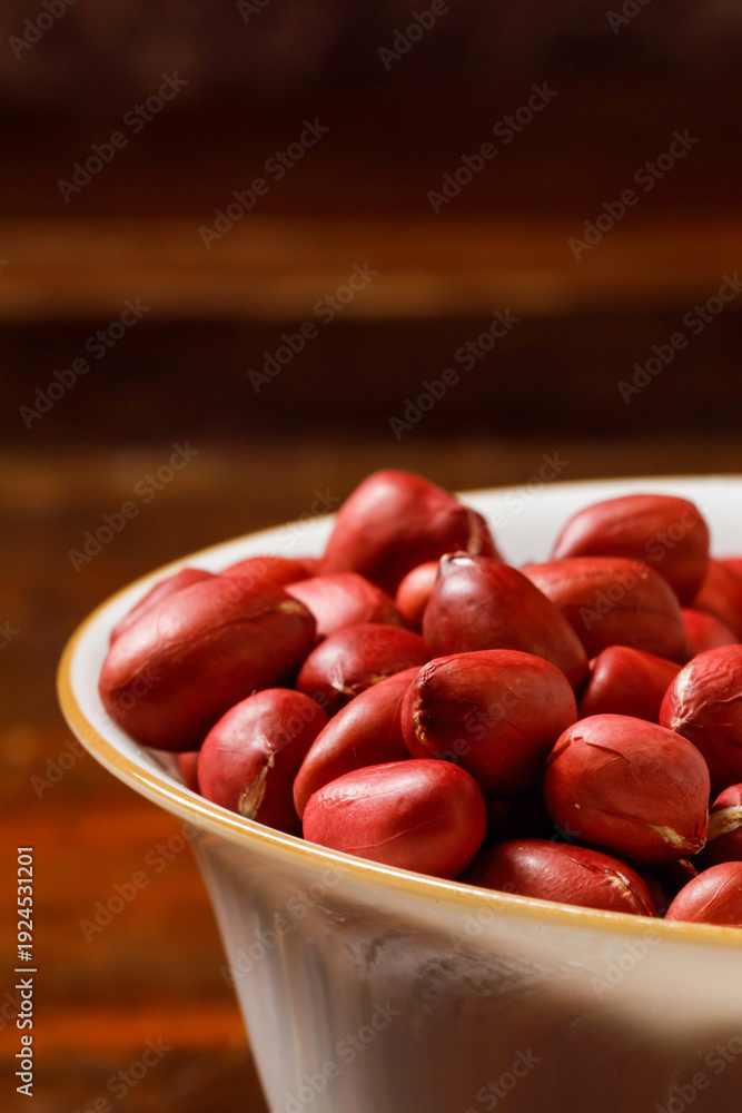 Obraz premium Red Skinned Peanuts in White Bowl