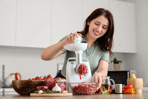 Young woman using meat grin...