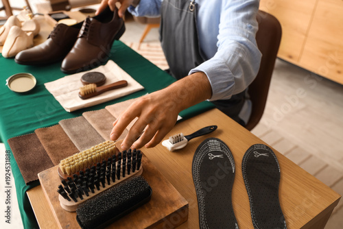 Male shoemaker with brushes...