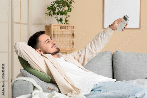 Happy young man turning on ...