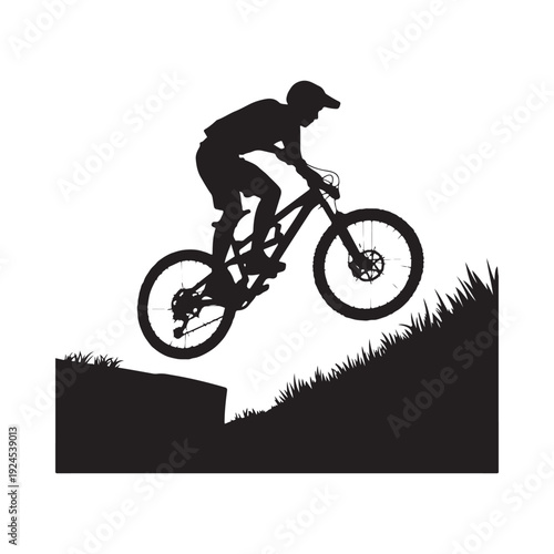 Silhouette of a mountain biker performing a jump against a bright background