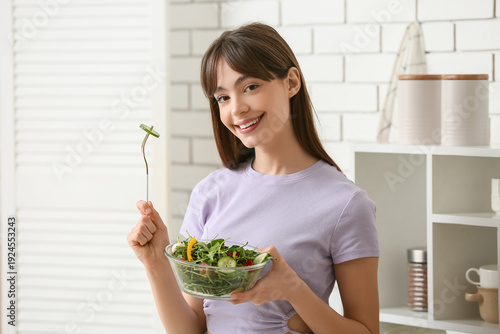 Young woman eating fresh ve...