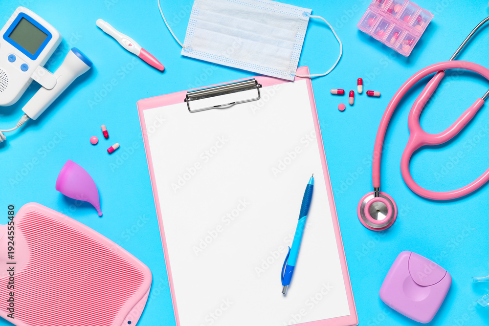 Obraz premium Blank clipboard with pills and medical supplies on blue background. World Health Day
