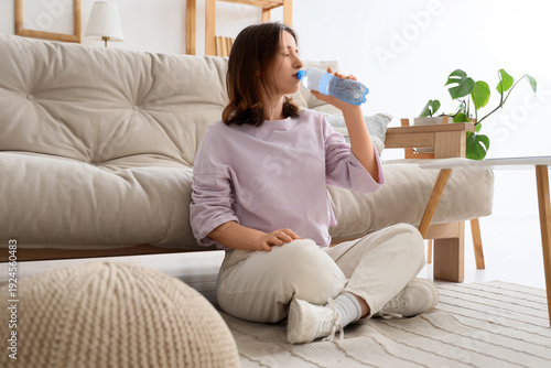 Young woman drinking water ...