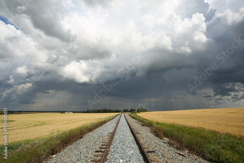 Train tracks leading into dramatic summer storm.