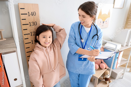 Female pediatrician measuri...