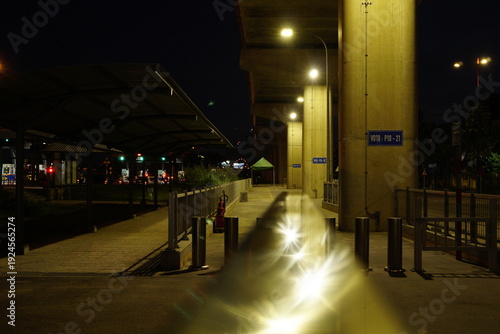 Fotografie Night Perspective of a City Underpass with Bright Street Lights and Concrete Pil