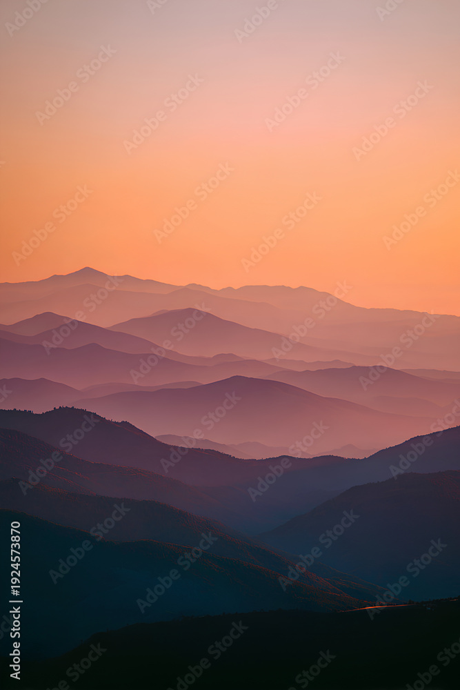 Obraz premium Layered Mountain Silhouettes at Sunset with Warm Orange Pink Gradient Sky Panoramic Serene Landscape