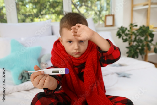 Sick little boy with thermo...