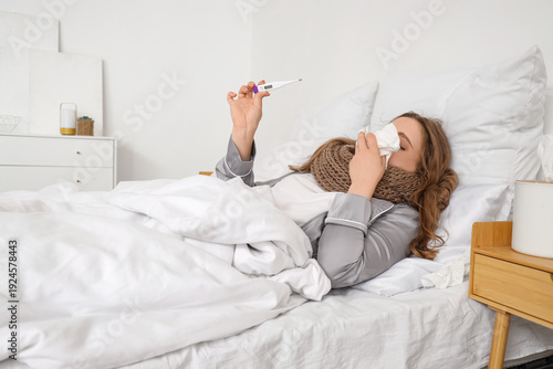 Ill young woman with thermo...