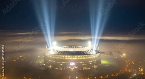 Brightly lit stadium with powerful searchlights piercing through heavy fog above a city at night under a starry sky