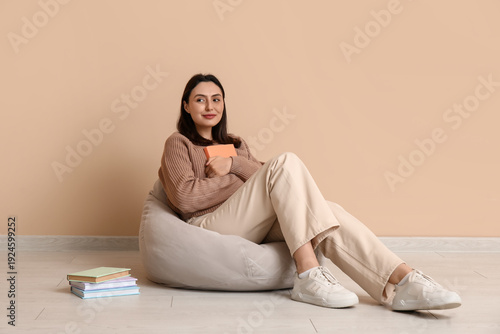 Young woman sitting on pouf...