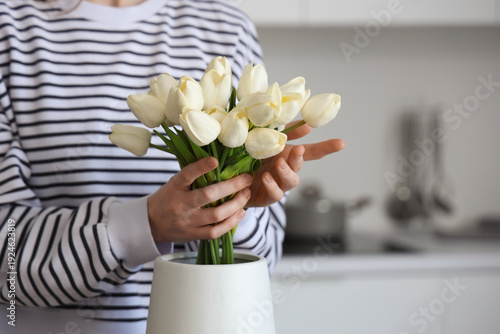 Woman putting bouquet of wh...