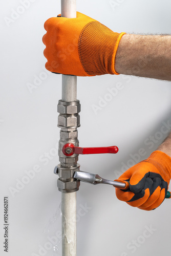 Technician plumber fixing leaking pipe of water.