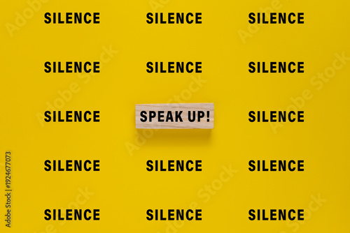 silence words and single speak up word. isolated on yellow background. concept of advocacy