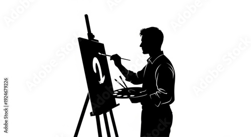 Silhouette of a man painting on an easel
