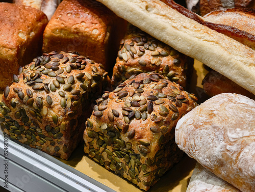 Freshly baked artisan bread selection abundant with seeds and grains displayed at a bustling bakery in the heart of the city
