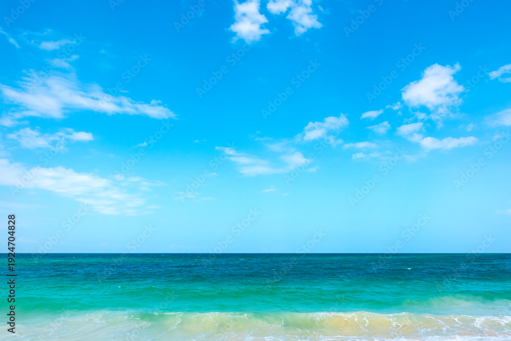 Obraz premium Tropical Nature clear sky and summer sea water under a clear blue sky with beautiful clouds and bright sunlight. Perfect for summer vacation and travel background
