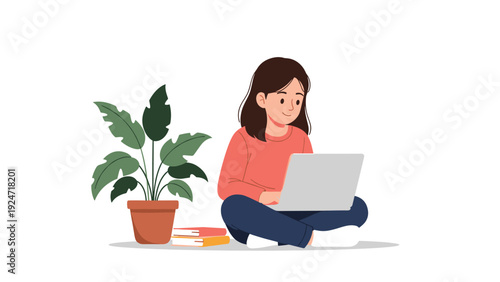 Young girl sitting cross-legged on the floor and working on her laptop computer next to a potted plant and books.