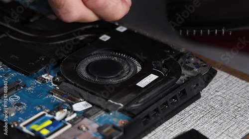 Laptop fan repair and internal cleaning process with screwdriver to restore cooling system and prevent overheating close up technical maintenance concept