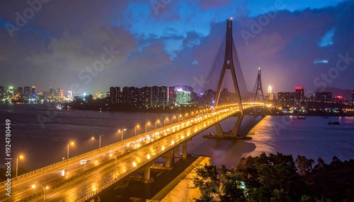 Nighttime View of a Modern Bridge Spanning a River with City Lights.