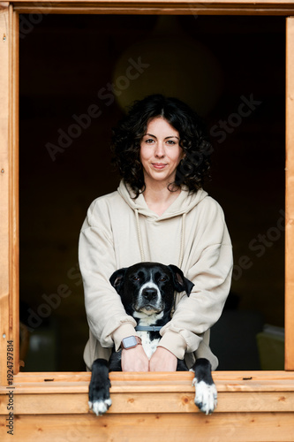Young woman and dog enjoying companionship through window