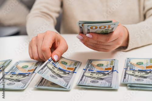 Tableau sur toile Close up of man counting dollar banknotes and separating them into stacks