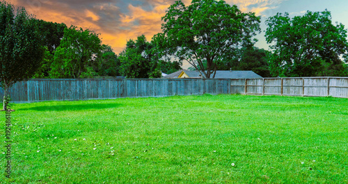 Принти на полотні A nice large backyard with a fence and trees, lovely sunset