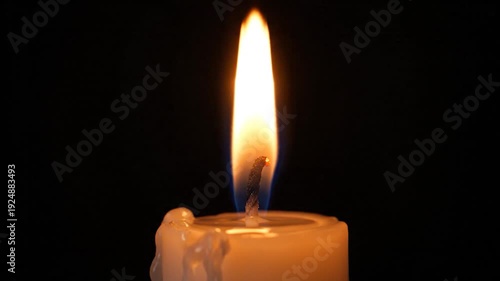 A match ignites a candle wick, creating a burst of bright sparks in the dark.