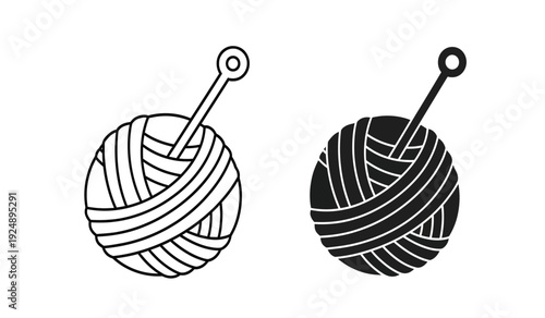 Two black and white yarn balls with knitting needles on a pure