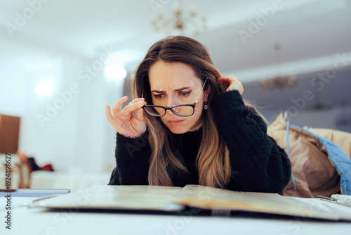 Woman Takes Off Her Glasses to Read the Menu at a Restaurant. Lady looking worried reading the food list to look for possible allergens 