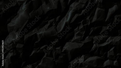 Crumpled dark paper texture with deep shadows and creases
