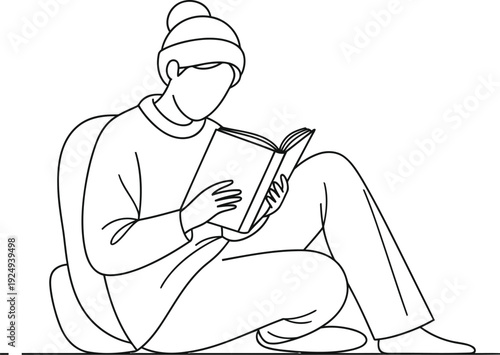 Person sitting outdoors engrossed in reading a book or digital device.