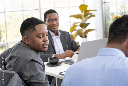 Black business professional looking at colleague while working in office