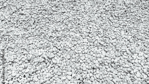 Detailed close up of many small bright white crushed stones making a rough natural surface background