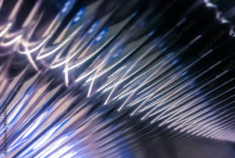 Obraz premium Macro view of shimmering glass surface with repeating patterns and cool blue light, creating a futuristic texture.