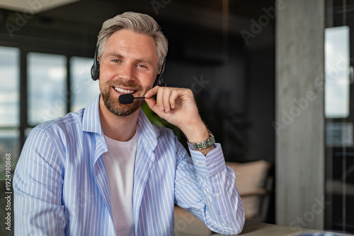 Businessman wearing headset working in home to support remote customer or colleague