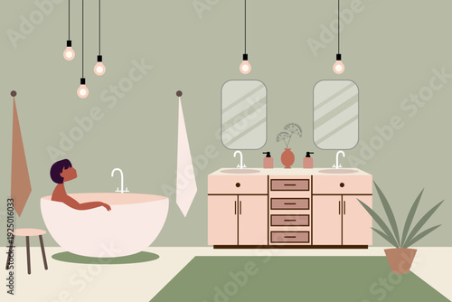 Young woman relaxing in a free standing bathtub in a modern bathroom