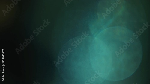 Light leak and bokeh overlay featuring soft green and dark teal hues with gentle light flares. This animation is ideal for adding atmosphere and visual interest to video projects.